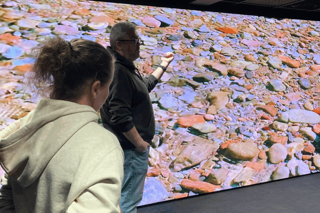 Two people in front of a huge screen in a laboratory