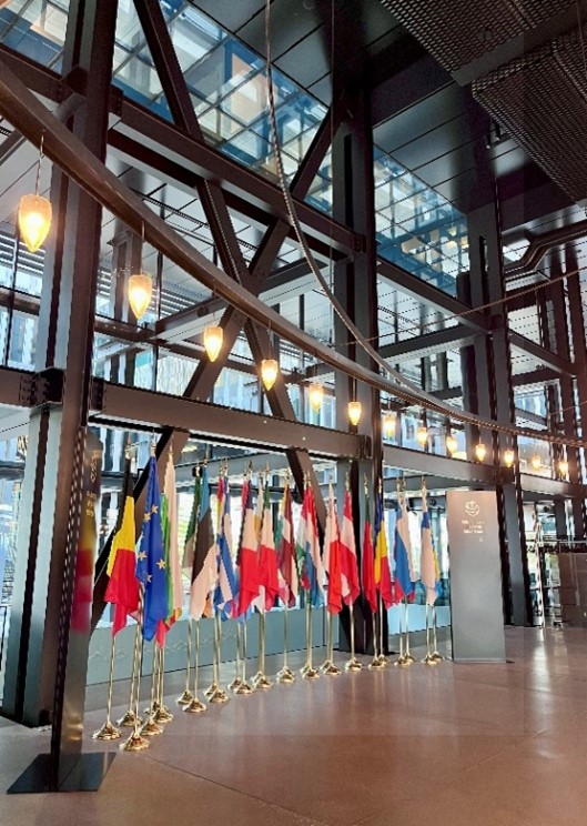 Korkea huone, jonka lattialla on rivi Euroopan valtioiden lippuja matalissa lipputangoissa.