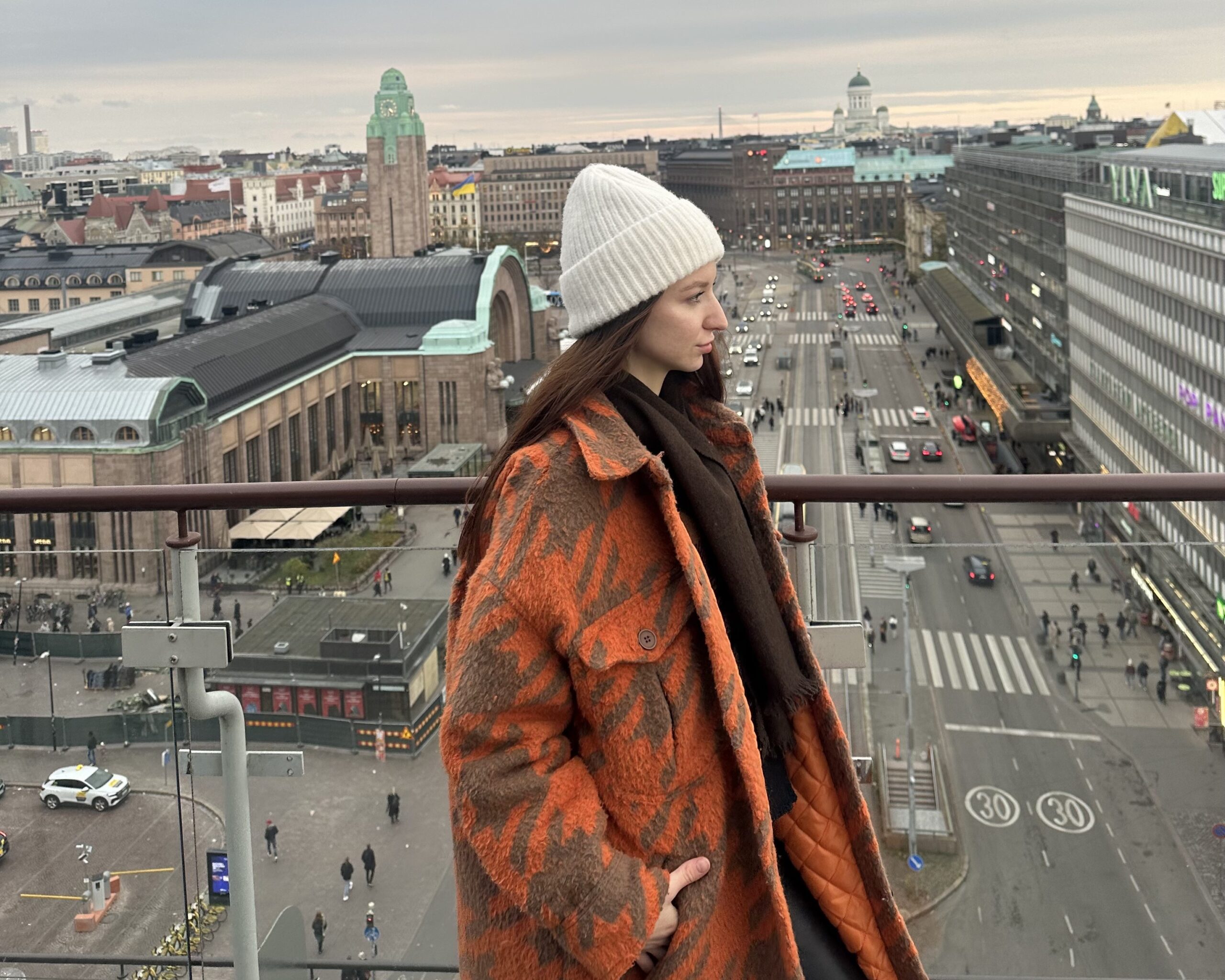 Nainen parvekkeella, taustalla näkymä Helsingin keskustaan.