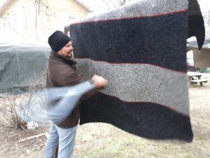 Man beating a carpet.