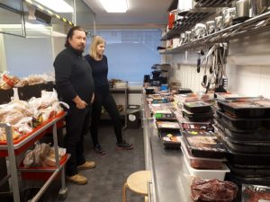 Two people in an institutional kitchen.