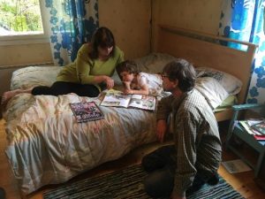 Olga Karlova ja Pekka Suutari lukevat kirjaa Miitrei-pojan kanssa