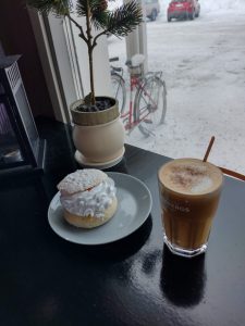 Kahvi ja laskiaispulla, ikkunan takana talvinen parkkipaikka