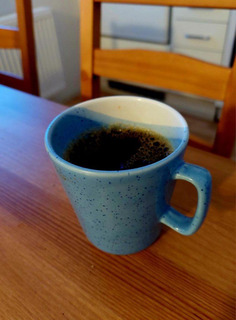 Sinivakoinen kuppi, jossa on kahvia