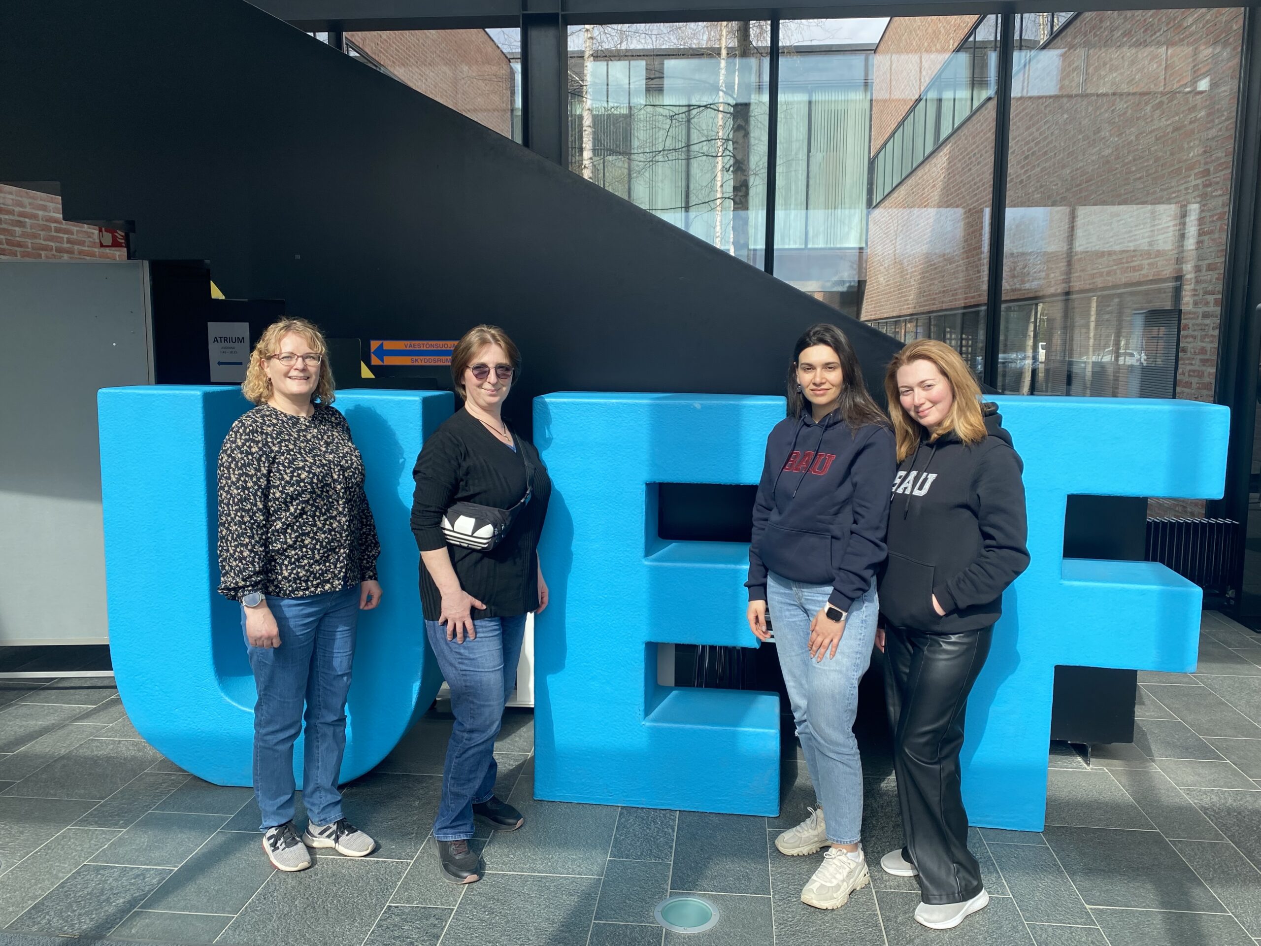 People standing in front of big letters.