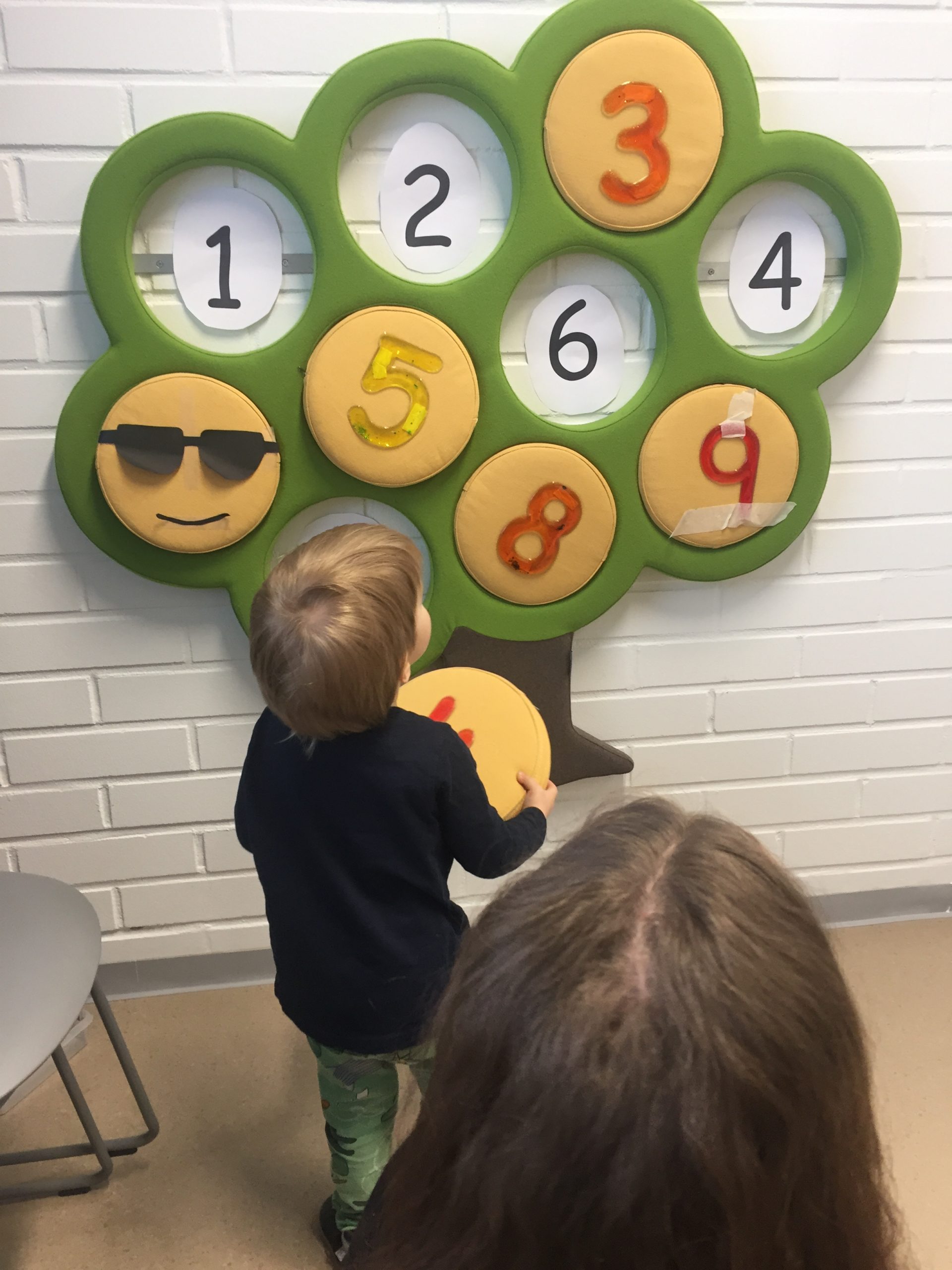 Lapsi sijoittaa numeropalan oikealla paikalle numeropuuhun.