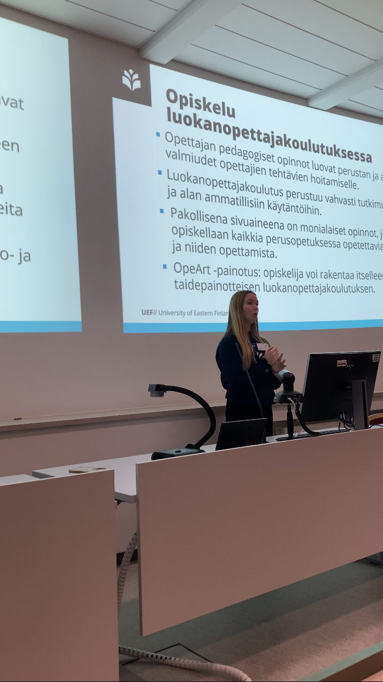 UEF-lähettiläs Linnea pitämässä luentosalissa esittelyä opiskelusta luokanopettajakoulutuksessa.
