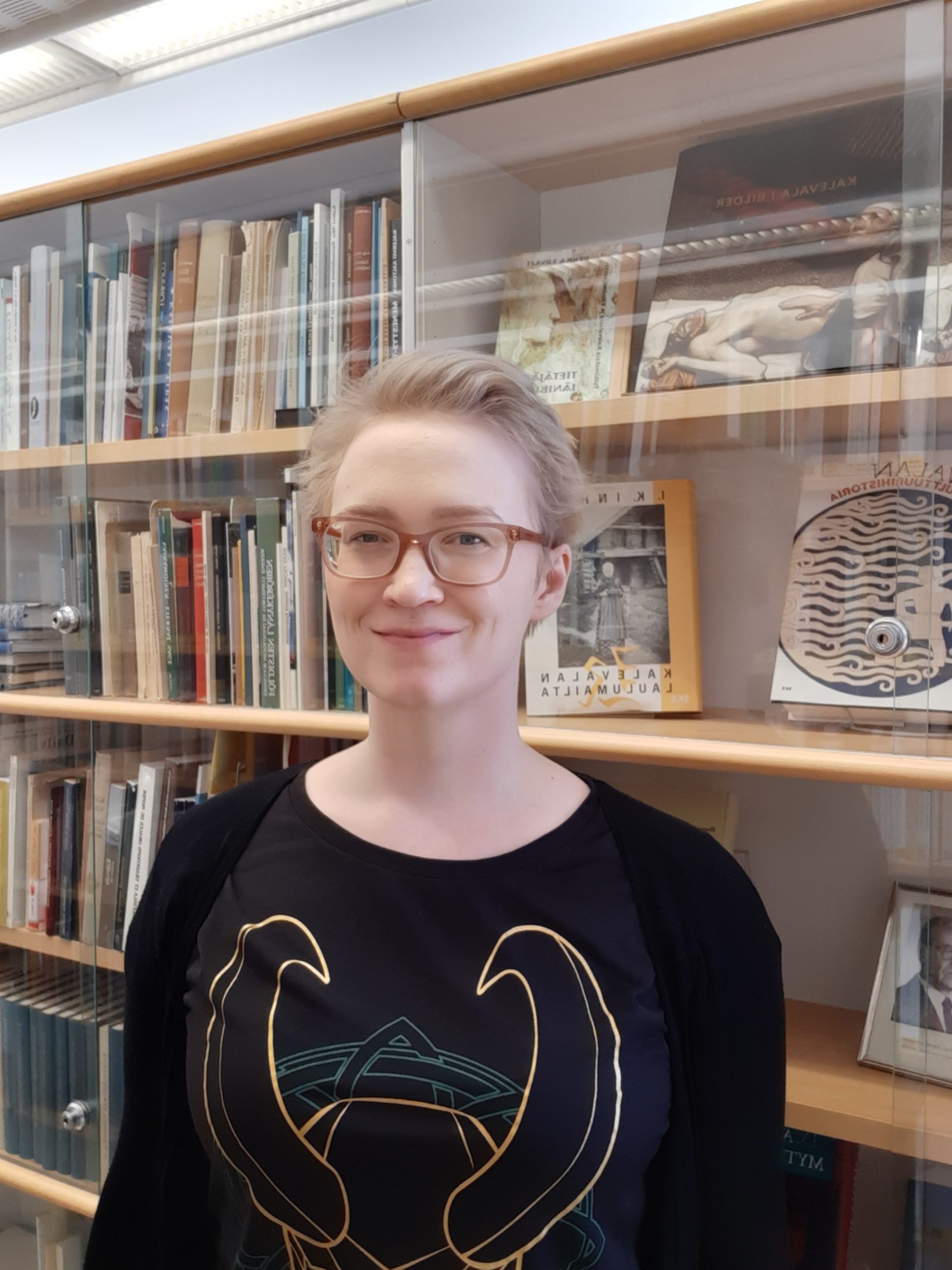 Hanna kirjahyllyn edessä. Hanna in front of a book shelf.