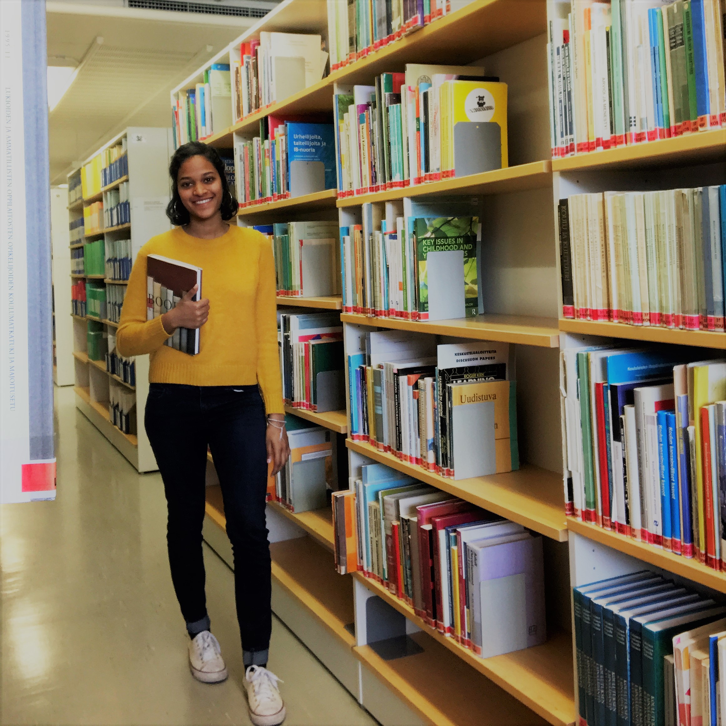 Nainen, kirjahylly, kirjoja. Woman, bookshelf, books.