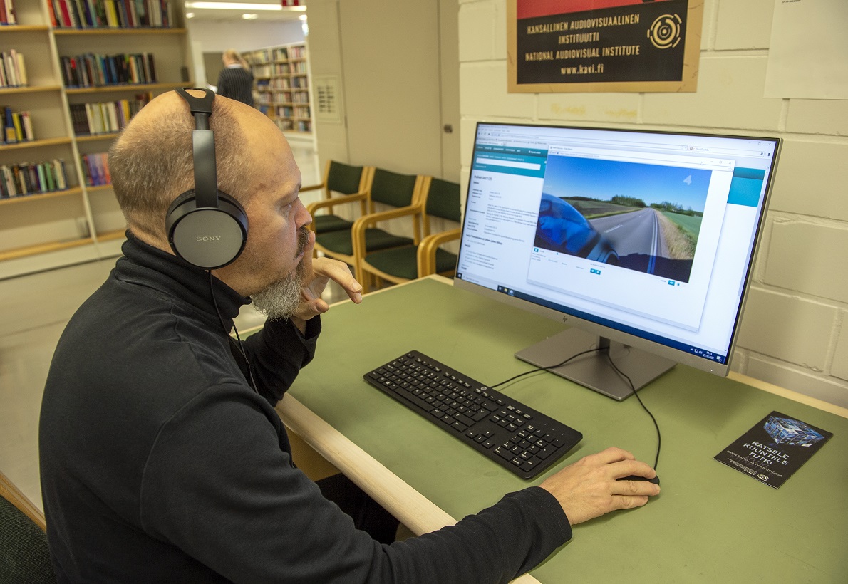 Mies kuulokkeet päässä tietokoneella | A man with headphones at a computer