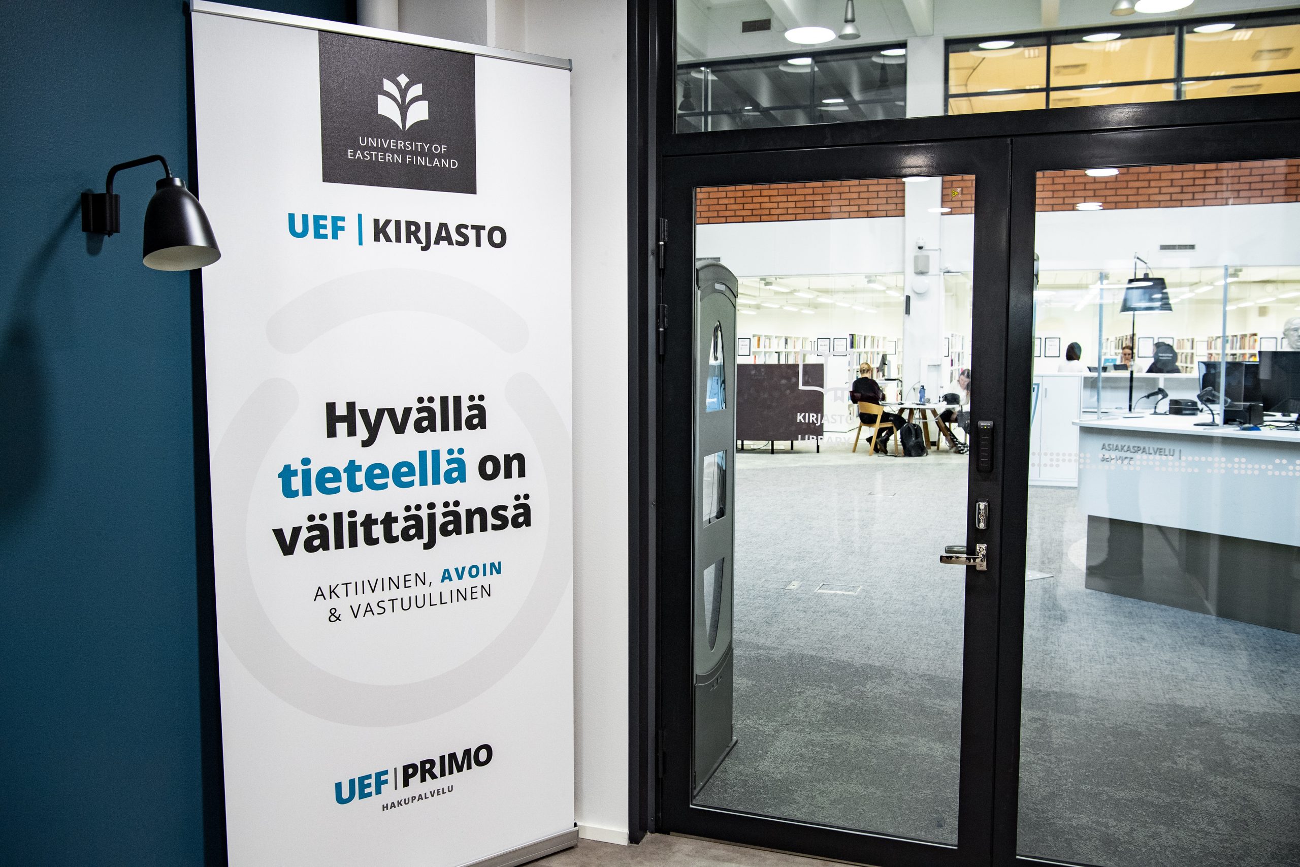 Näkymä oven läpi Kuopion kampuskirjastoon | A view through a door to the Kuopio Campus Library.