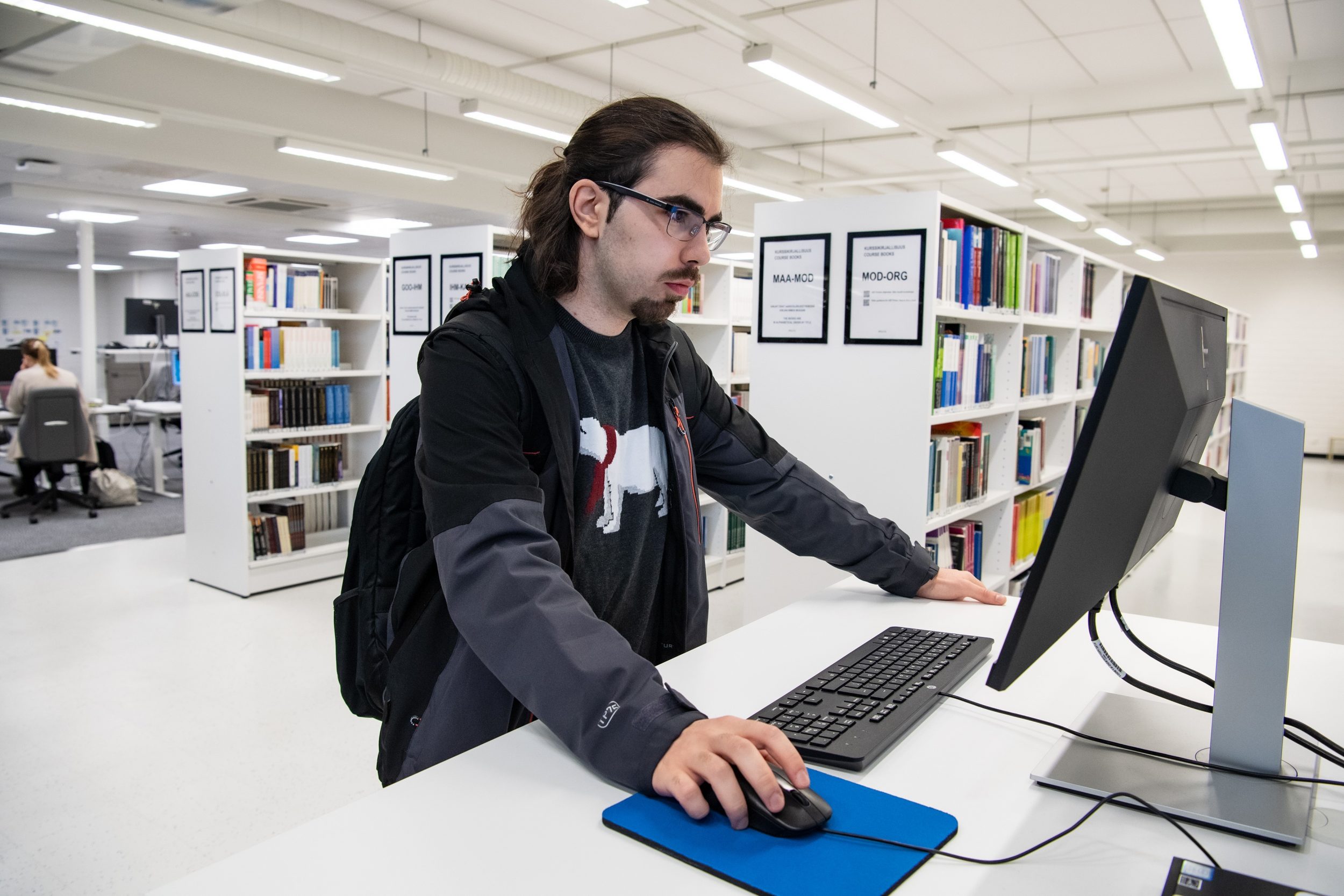 Henkilö kirjaston Primo-päätteellä. | Person at the library's Primo computer.