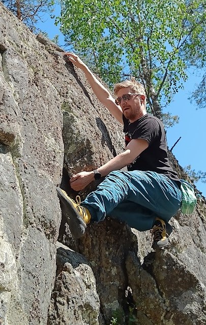 Tietojärjestelmäsuunnittelija kiipeilemässä kalliolla. An information system designer climbing a cliff.