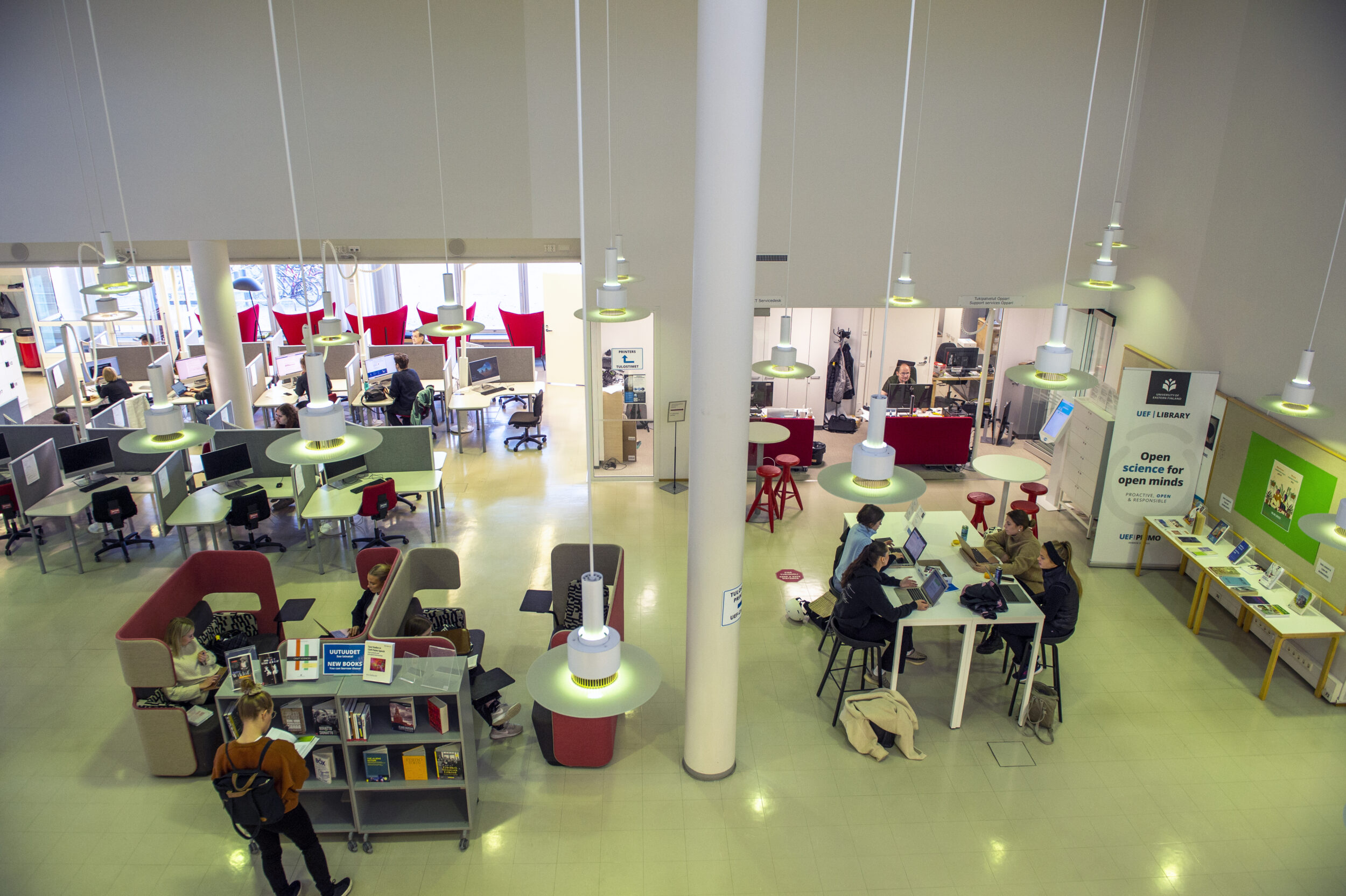 Joensuun kampuskirjaston 1. kerroksen opiskelutiloja sekä Opparin palvelupiste kirjaston sisällä. |  Study facilities on the 1st floor of Joensuu Campus Library and Oppari's customer service desk inside the library.