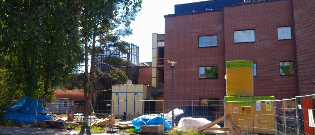 Punatiilisen rakennuksen rakennustyömaa.