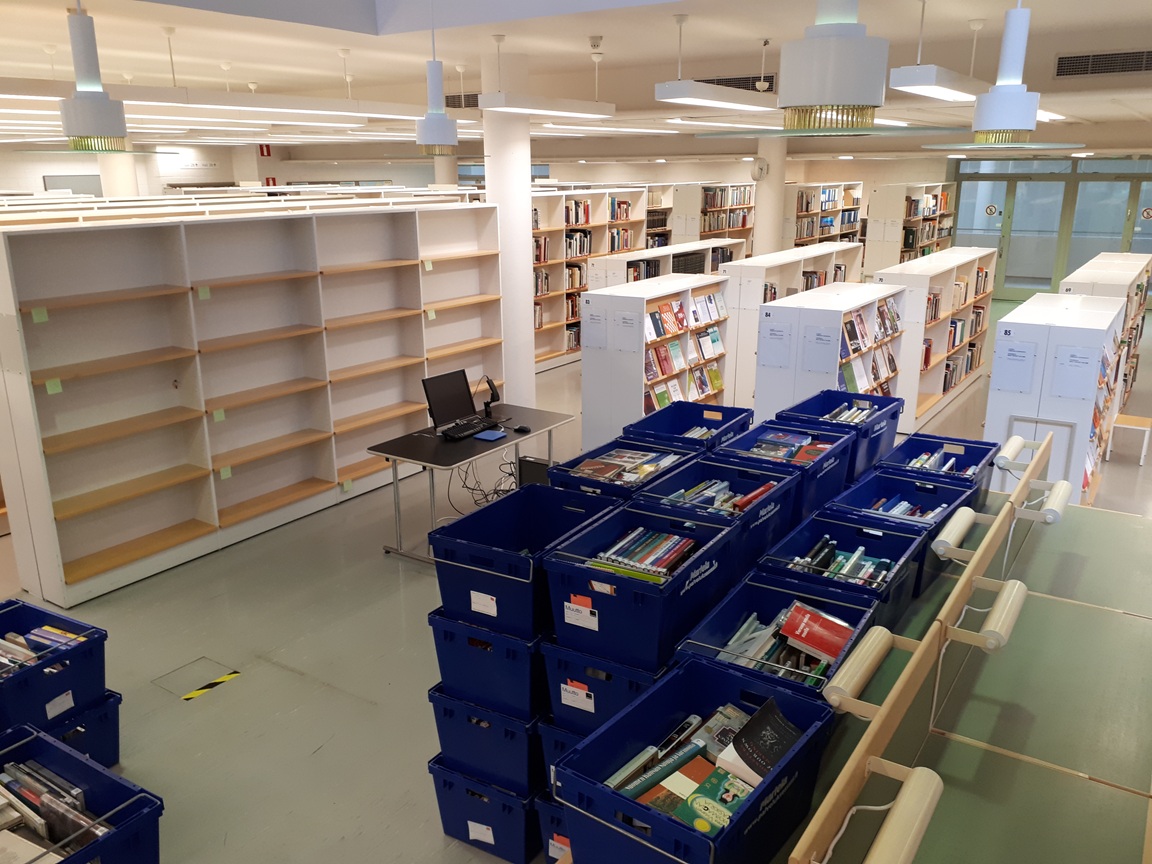 Kirjastosali, jonka lattialla kirjalaatikoita.