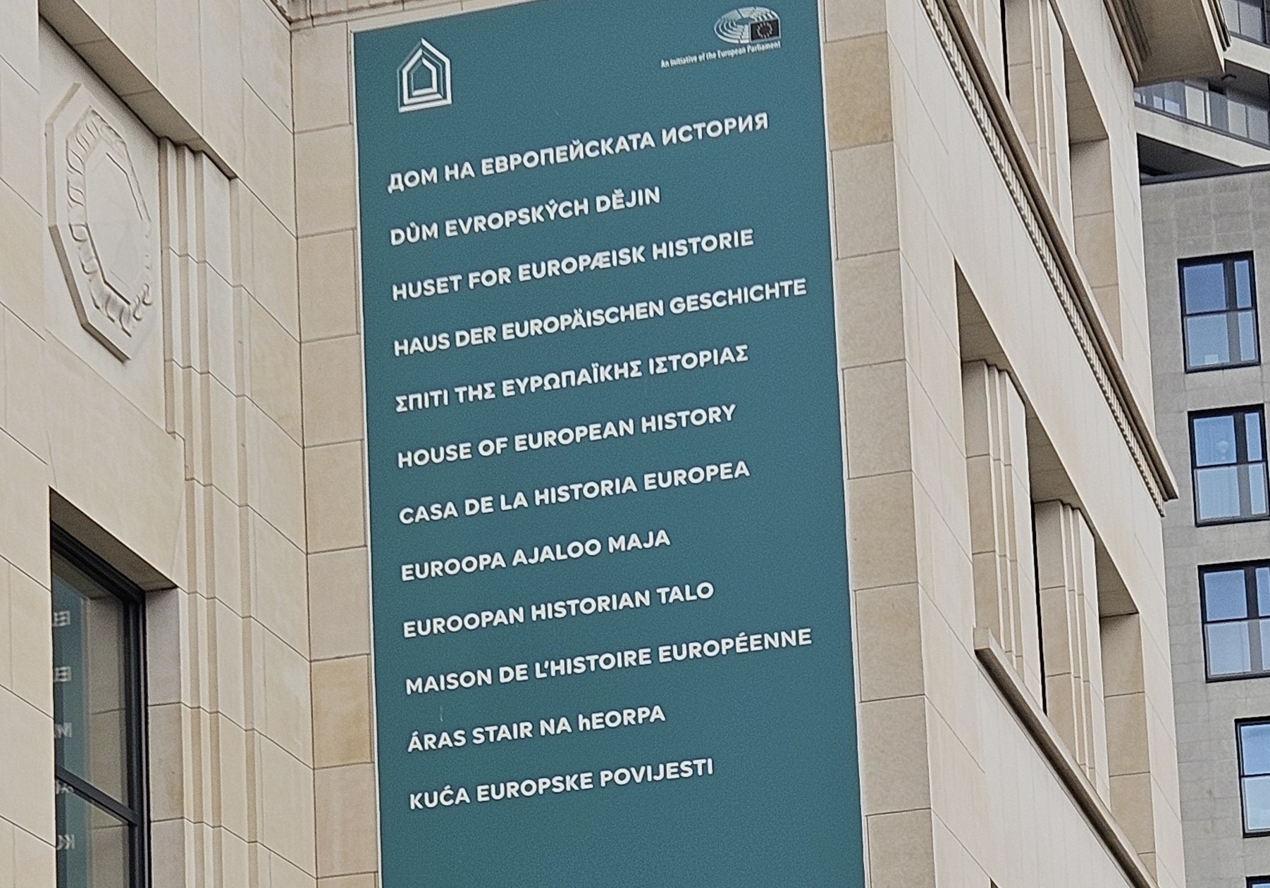 Euroopan historia talon nimi on kirjoitettu useilla kielillä mainoskankaalle. | The name of the House of European History is written in several languages on a banner.