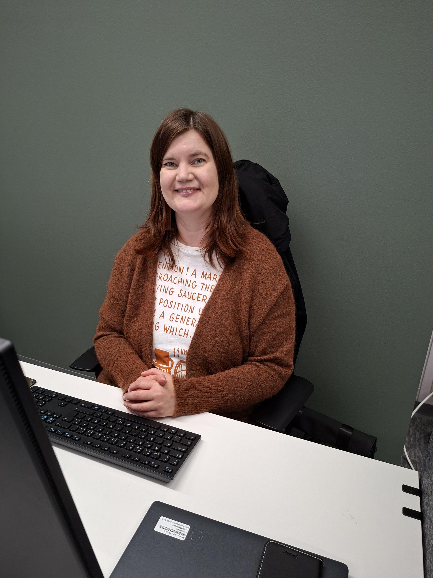 Eija Mustonen työpöytänsä ääressä. | Eija Mustonen at her desk.
