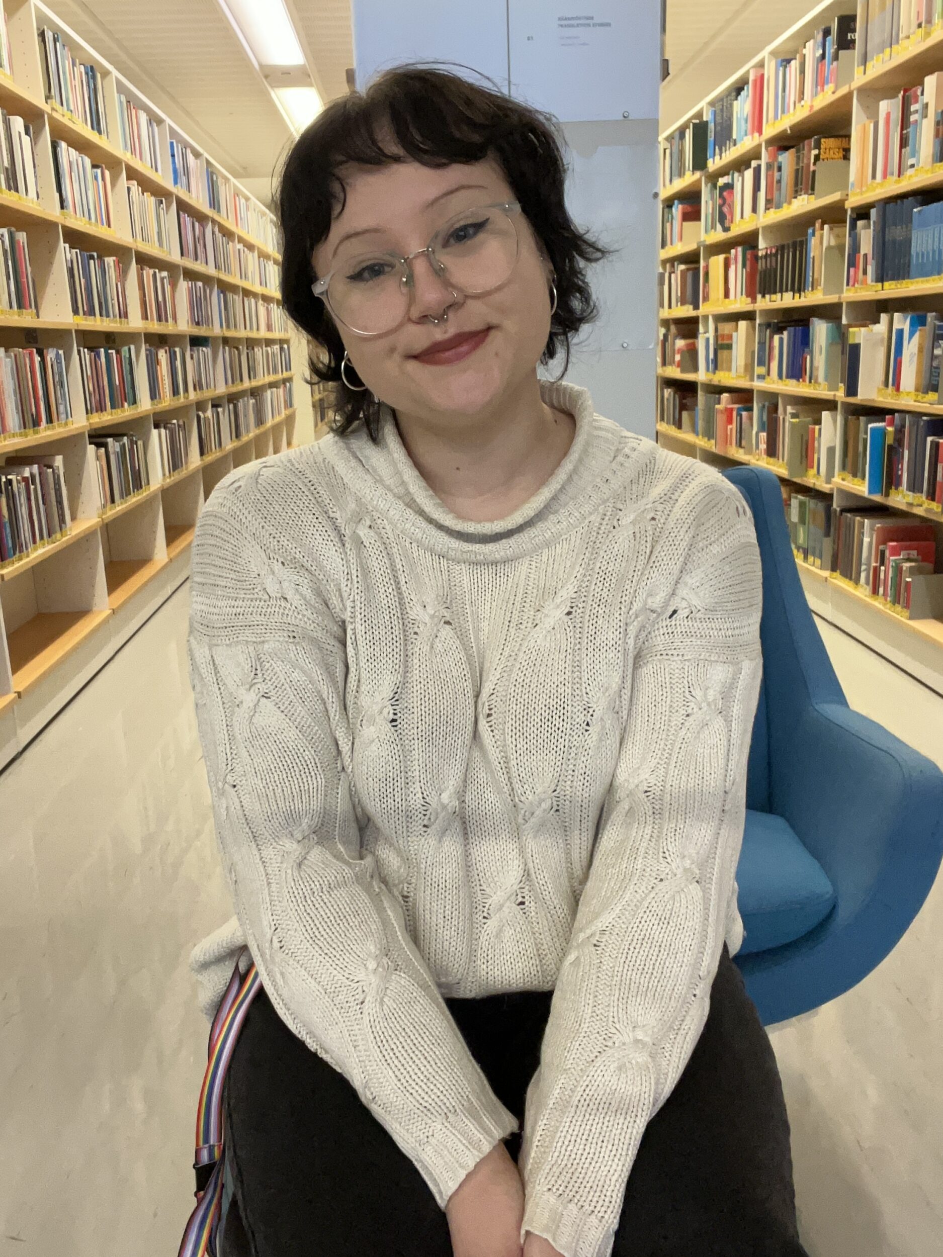 Harjoittelija kirjaston salissa. Intern in the library hall.